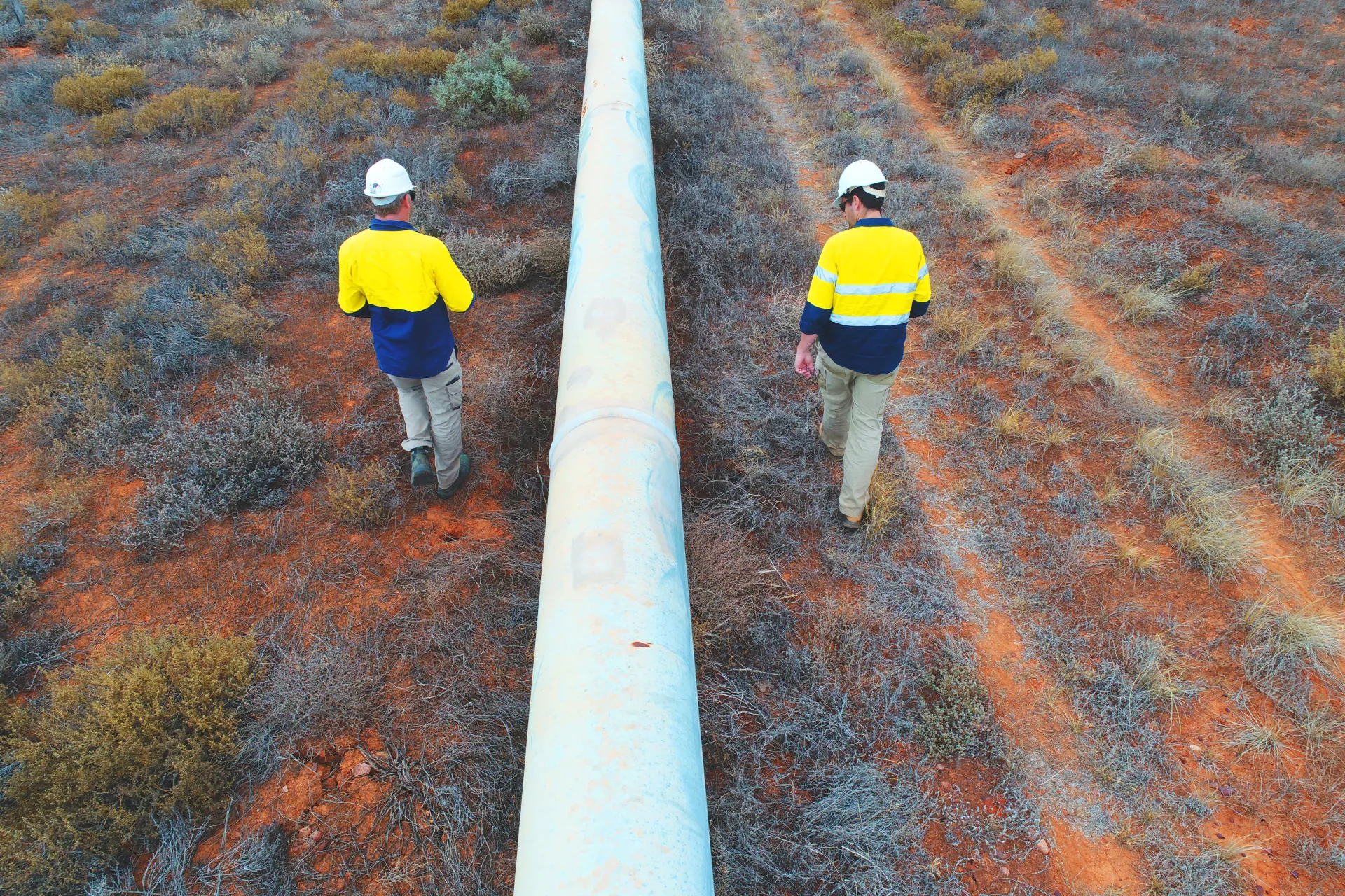 People walking along oil and gas pipeline