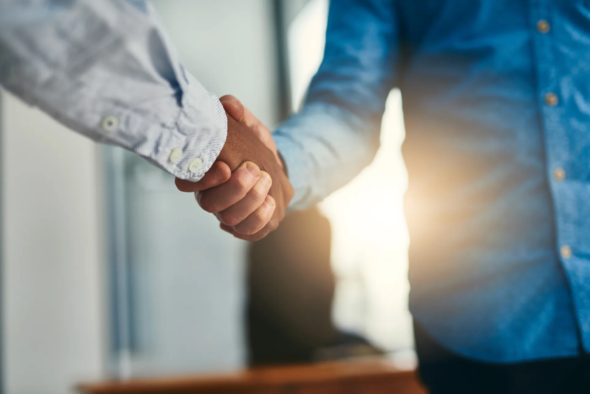 Closeup shot of businesspeople shaking hands in an office.